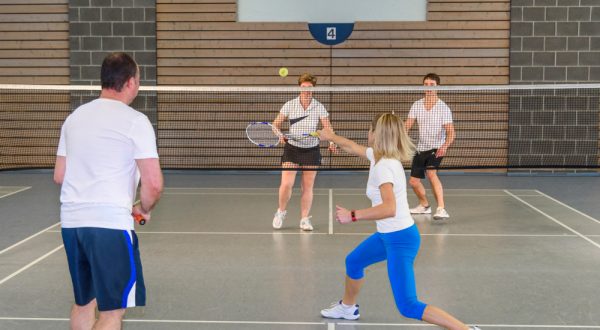 Four people playing badminton
