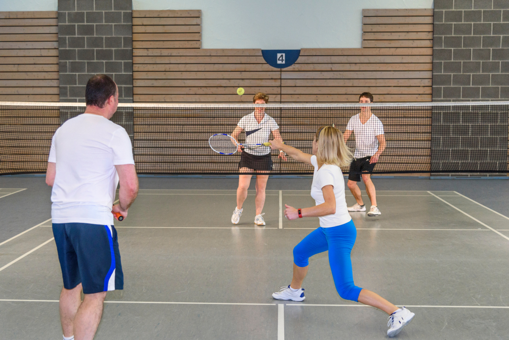 Four people playing badminton